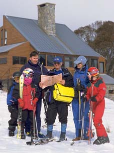 1986 photograph of a census collector with a family in ski gear at a snowfield.