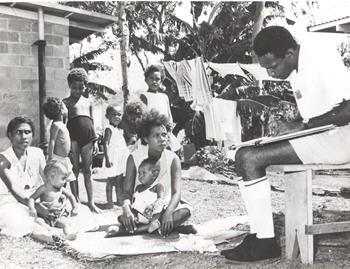 A census collector in Papua New Guinea 1966, collects information from a family 