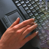A hand typing on a computer keyboard