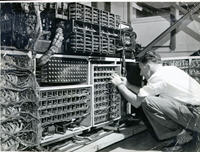 George Crossman undertaking maintenance at the back of a Census trio machine, showing large quantities of wiring