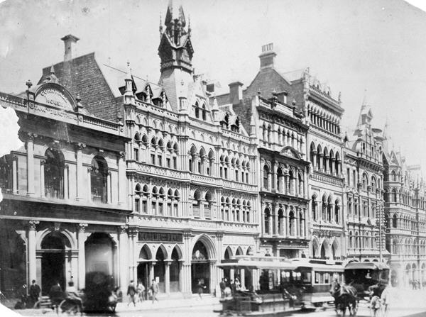 Photograph of the old Rialto Building, Collins street Melbourne. Trams and horse drawn carriages can be seen on the street.