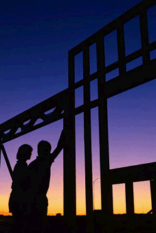 Silhouette of two people and a building frame