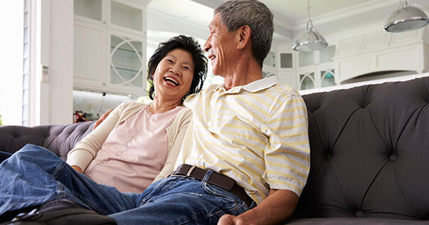 Older couple laughing in living room