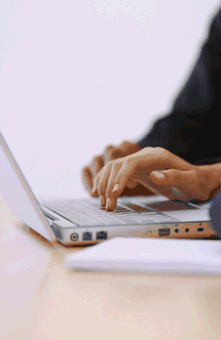 Image: A laptop computer, with someone typing